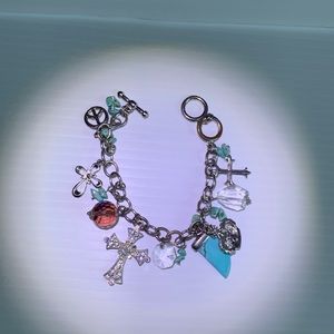 Silver toned charm bracelet with rhinestones, turquoise, glass, beads.